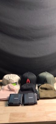 many hats and cell phones sitting on a table
