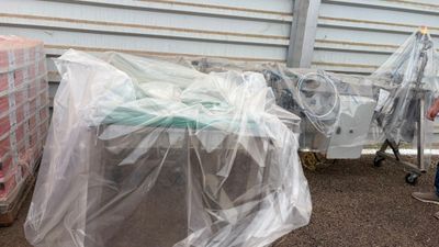 un homme qui se tient à côté d'un camion sur lequel sont posés des sacs