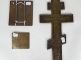 three pieces of metal and a wooden cross on a white surface