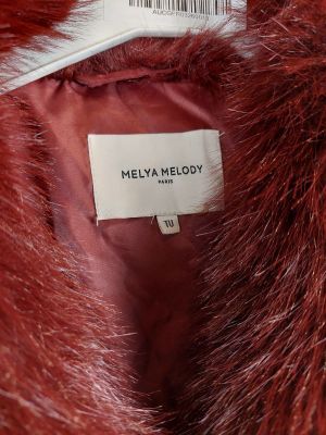 un gros plan sur un manteau de fourrure rouge portant une étiquette