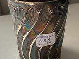 a silver cup with a tag on it sitting on a table