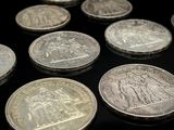 quelques pièces d'argent posées les unes à côté des autres sur une surface noire