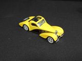 a yellow toy car sitting on a black surface