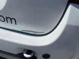 the rear end of a white car with the word mom written on it