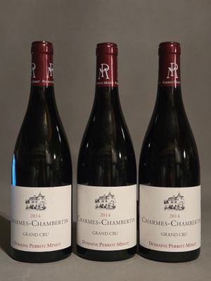trois bouteilles de vin rouge sont alignées sur une table
