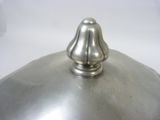 a silver lid on a silver pot on a white surface