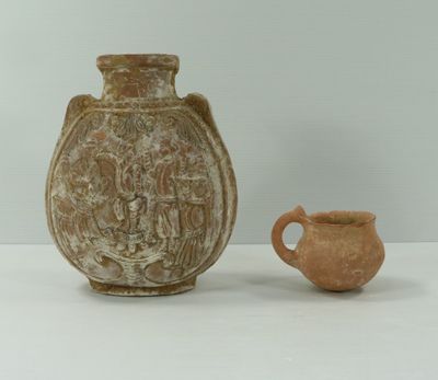 un petit vase et une petite tasse posés sur une table
