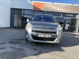 the front of a silver citrole parked in front of a building