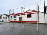 une clôture rouge et blanche devant un bâtiment blanc