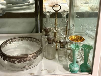 une vitrine en verre contenant un bol et d'autres objets en verre