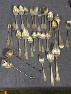 beaucoup de cuillères en argent et de cuillères à soupe sur une table