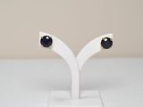 a pair of black and white earrings on a white stand