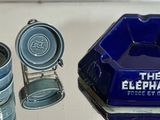 a blue glass ashtray and four blue cups on a table