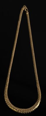gros plan d'un collier en or sur fond noir