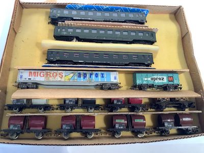 beaucoup de petits trains dans une boîte posée sur la table