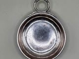 an old silver plate with a ring hanging from it ' s side