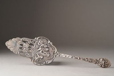 an antique silver spoon with a flower design on it