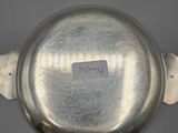 a close up of a silver pot with a label on it