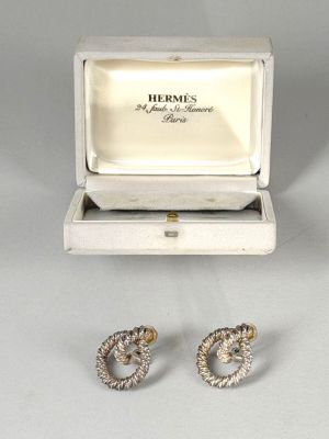 a pair of earrings in a box with a ring inside of it