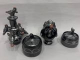 trois figurines en céramique noire sont posées sur une surface blanche