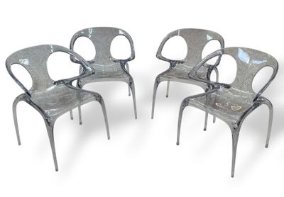 trois chaises en plastique transparent placées les unes à côté des autres sur une surface blanche