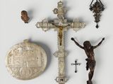 un crucifix, une croix et d'autres objets religieux posés sur une surface blanche