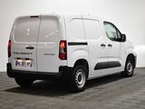 the back end of a white van is parked in a room