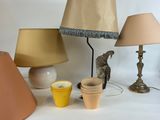 a table with a lamp, vases, and a bird on it