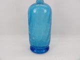 a blue glass bottle that is sitting on a table