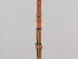 an orange and black instrument sitting on top of a glass stand