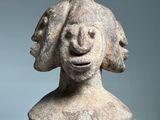 an old statue of a woman with a bird on her head