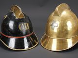 pair of firemen ' s helmets on a black background
