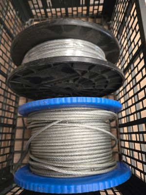 un gros plan sur une bobine de fil métallique dans un panier posé sur une étagère
