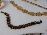 many different types of necklaces and bracelets on the table