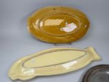 three pieces of yellow pottery sitting on top of a white table