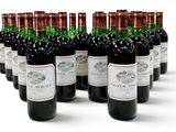 bottles of red wine lined up in a row on a white surface