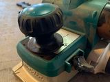 a green machine that is sitting on a wooden floor