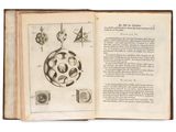 un livre ouvert sur lequel figure le dessin d'un objet circulaire