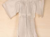 a picture of a white dress hanging on a wooden wall