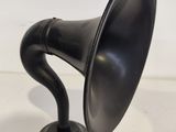 an old fashioned black gramphone sitting on top of a white table