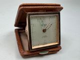 une petite horloge posée dans une boîte sur une table