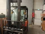a forklift in a warehouse filled with boxes and boxes