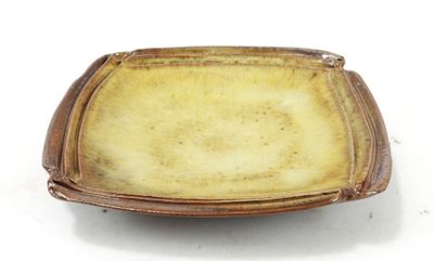 a brown plate with a brown rim on a white surface