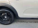 a small white car that is parked on the side of the road