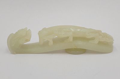 une image représentant une sculpture en jade blanc représentant un oiseau perché sur une branche