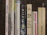 de nombreux livres posés sur une étagère posée sur une table