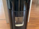 une photo d'une cafetière noire posée sur un parquet