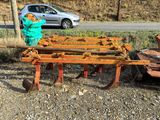 a tractor with a plow attached to it and a car in the background