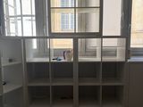 a room with a window, shelves, and a desk in it