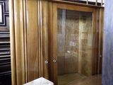 a wooden cabinet with a glass door in a room